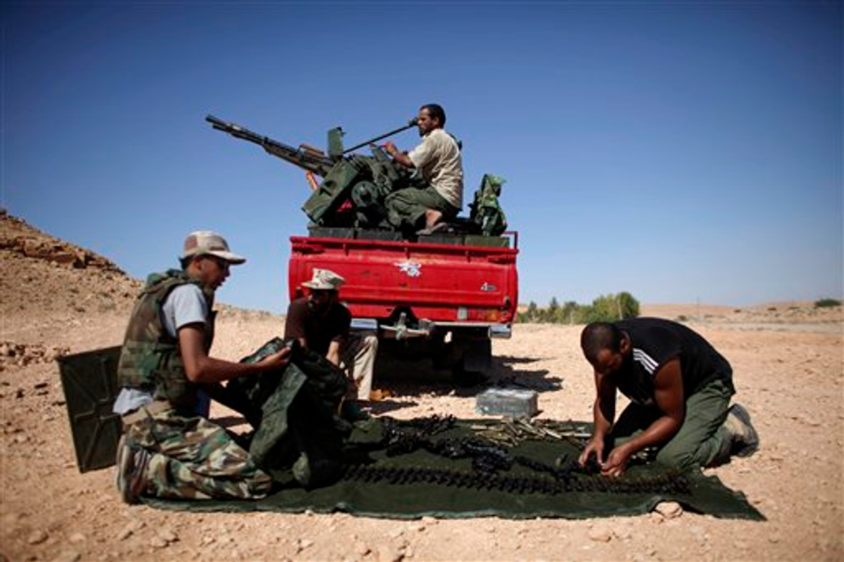 Former rebel fighters prepare an anti-aircraft weapon near the entrance of Bani Walid, Libya, Sunday, Sept. 11, 2011 
