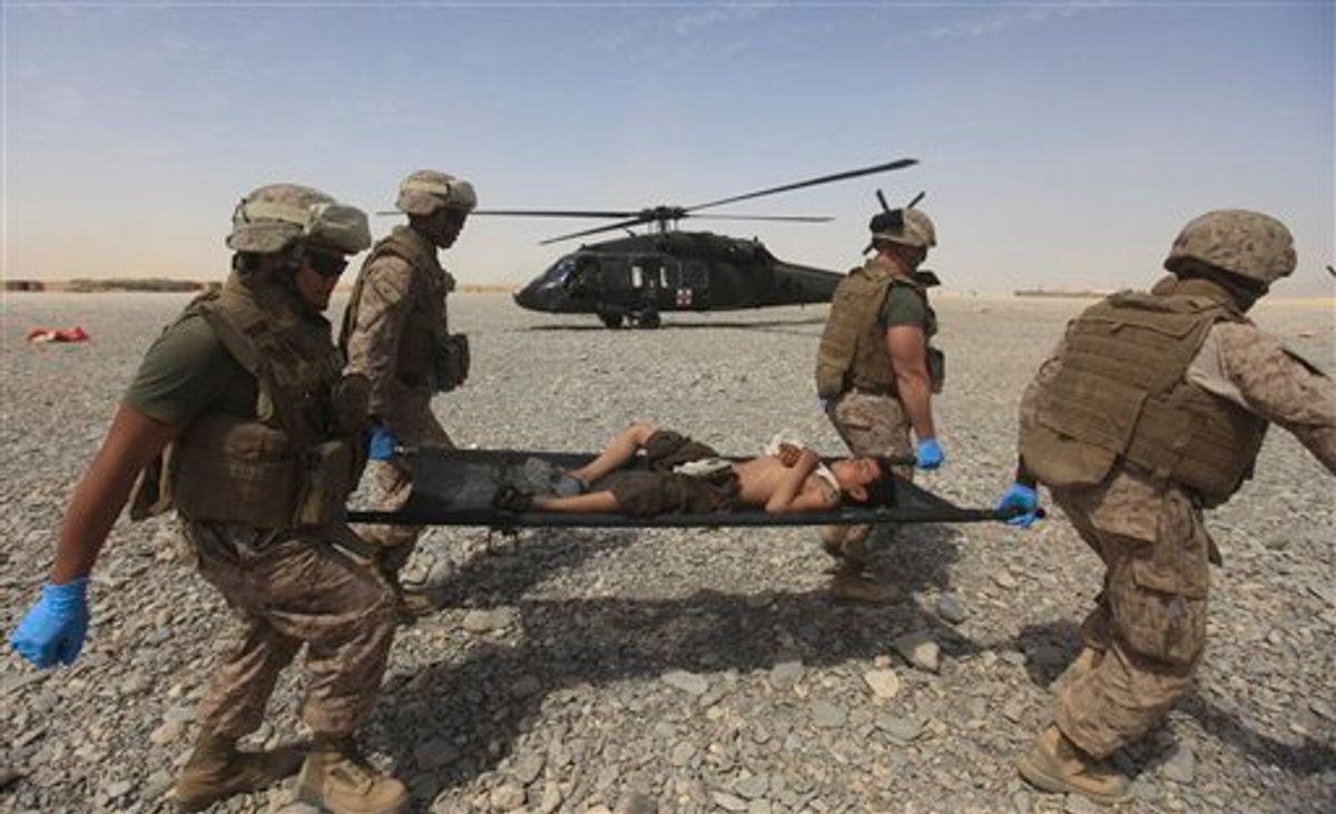 Medical nurses of U.S Marines carry the injuried Afghan boy to hospital after he fell from a wall at Forward Operating Base Edi in the Helmand Province of southern Afghanistan, Wednesday, Sept. 7, 2011.(AP Photo/Rafiq Maqbool) (AP)
