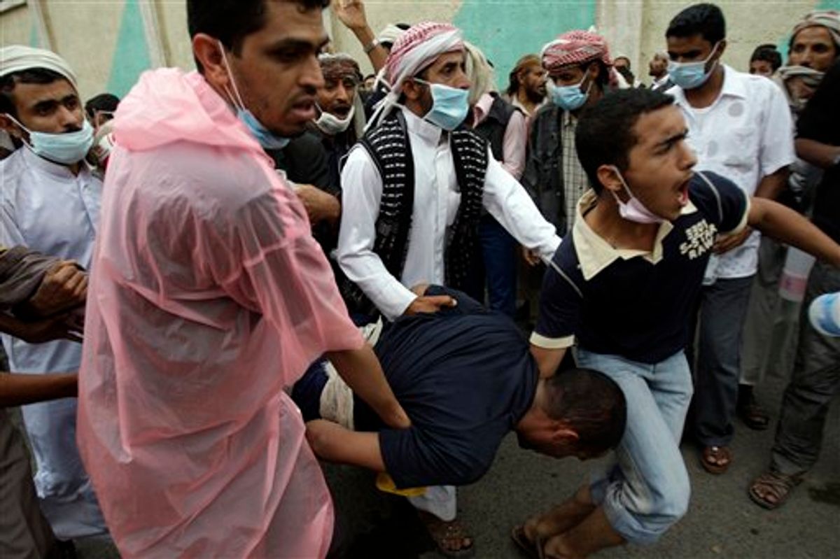 Anti-government protestors carry a wounded protestor from the site of clashes with security forces, in Sanaa, Yemen, Sunday, Sept. 18, 2011. Yemeni government forces opened fire with anti-aircraft guns and automatic weapons on tens of thousands of anti-government protesters in the capital pushing for ouster of longtime ruler Ali Abdullah Saleh, killing several people and wounding dozens.(AP Photo/Hani Mohammed) (AP)