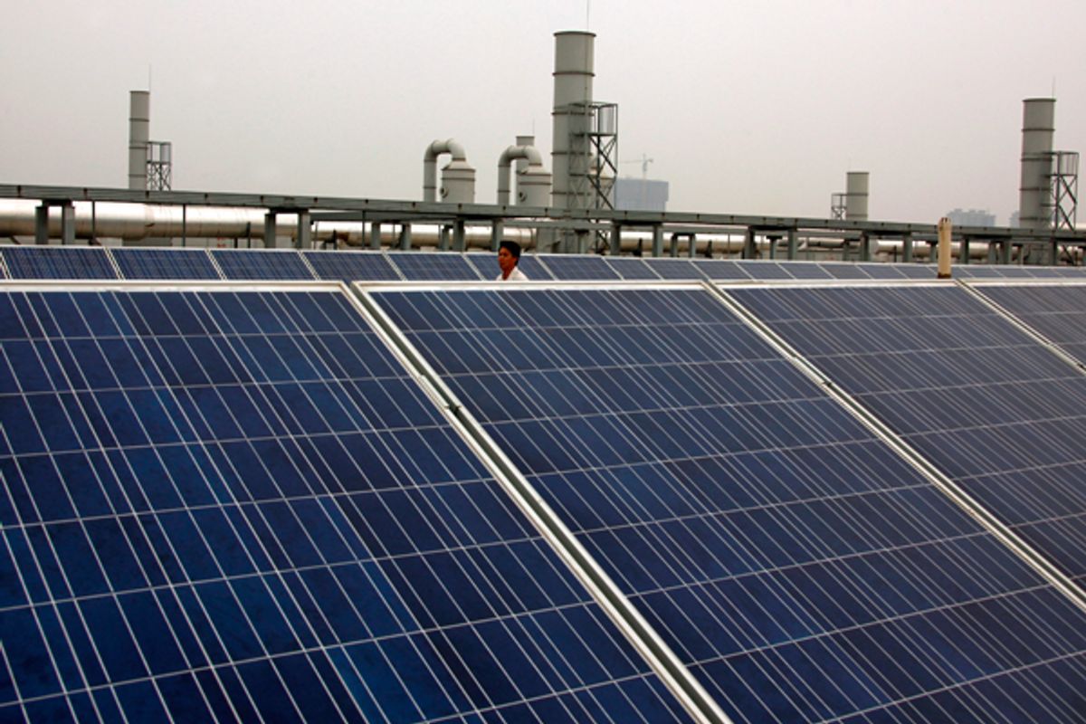 A worker walks behind solar panels on the factory roof of the Yingli Green Energy Holding Company in Baoding, Hebei Province. (Reuters/David Gray)