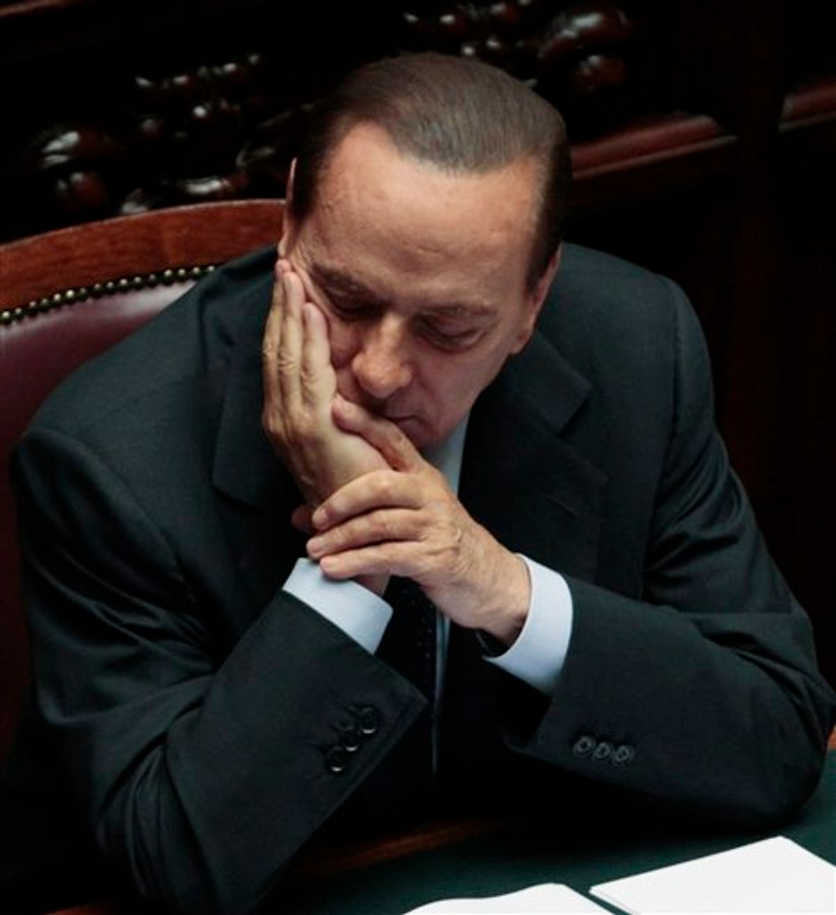 Italian Premier Silvio Berlusconi reacts prior to the start of a voting session in Parliament  on the Government's austerity package in Rome, Wednesday, Sept. 14, 2011.  Demonstrators, some armed with smoke bombs, clashed with police in Rome near Parliament on Wednesday night as Italian lawmakers prepared to cast a final vote on a package of new taxes and spending cuts designed to fend off a financial crisis threatening much of Europe. (AP Photo/Gregorio Borgia) (AP)