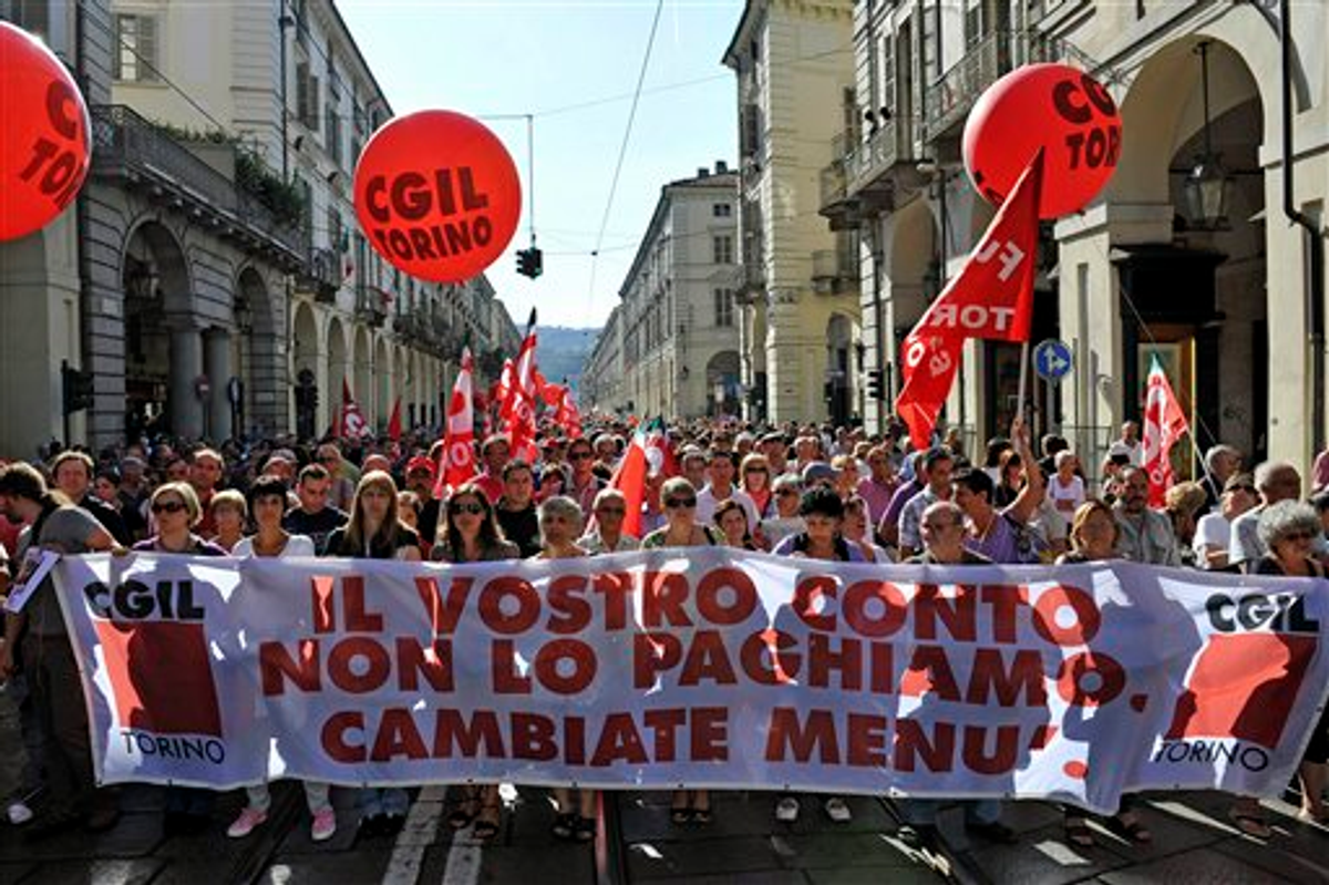 People hold a banner reading "We don't pay your bill, change the menu" as they march through downtown Turin, Italy, Tuesday, Sept. 6, 2011