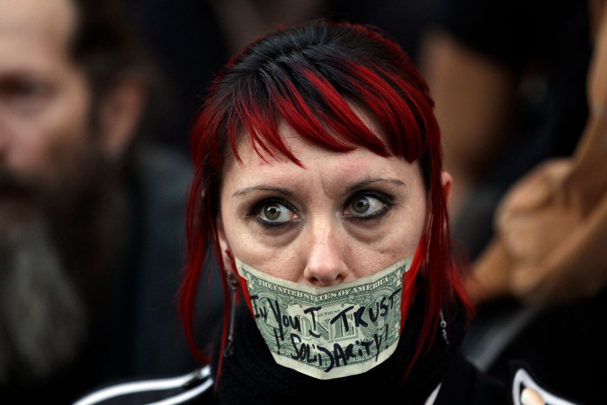 A protester tapes a dollar bill over her mouth at Occupy Oakland. (AP Photo/Marcio Jose Sanchez)