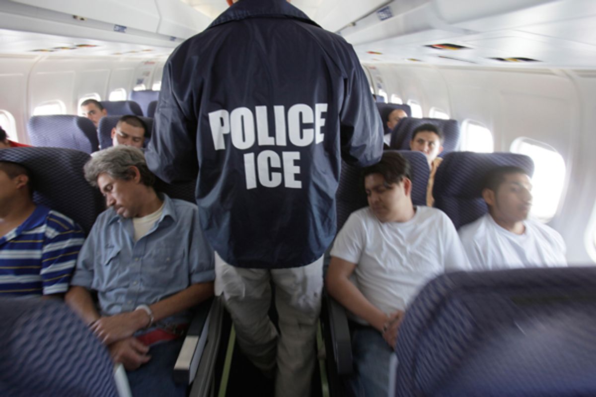  An Immigration and Customs Enforcement agent walks among shackled Mexican immigrants aboard a U.S. Immigration and Customs Enforcement charter jet.   (AP/LM Otero)