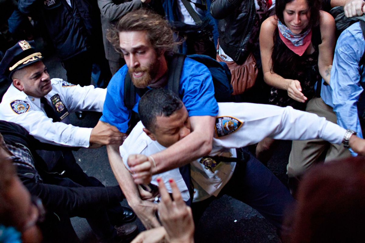 A man affiliated with the Occupy Wall Street protests tackles a police officer during a march towards Wall Street in New York, on Friday.  The Washington Post published this photo on its front page Saturday. (AP/Andrew Burton)