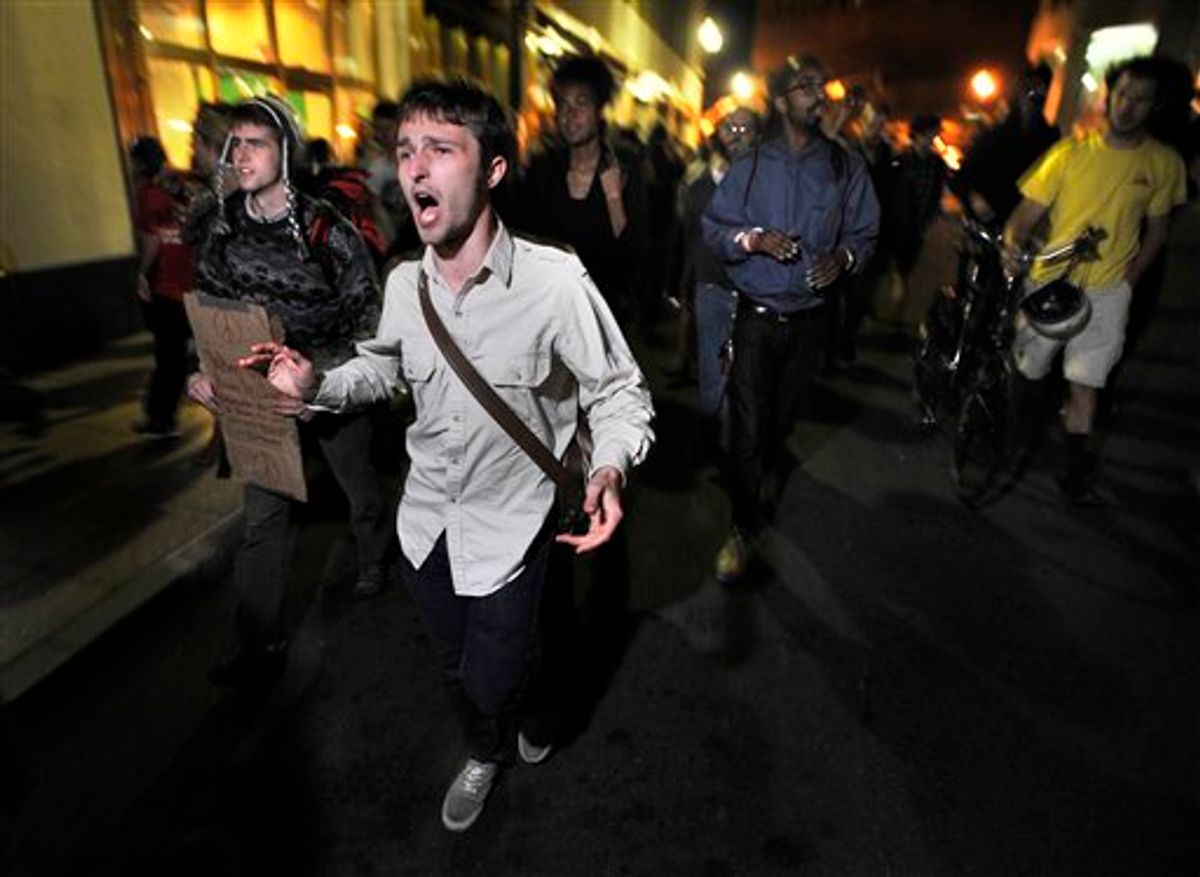 Demonstrators with "Occupy Boston" march toward  the police station where fellow demonstrators were brought after police arrested people sleeping in an expansion of the Occupy Boston tent village in Boston, in the early morning hours of Tuesday, Oct. 11, 2011.    (AP/Josh Reynolds)