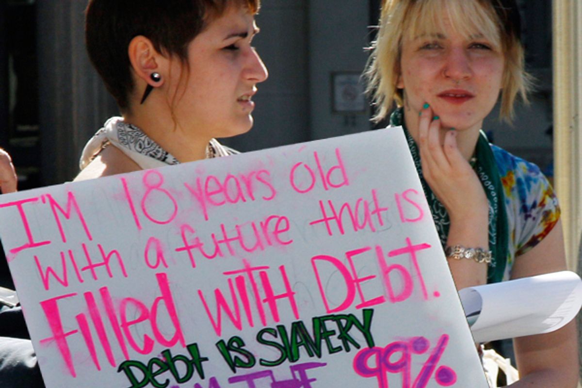 Two young women sit next to a sign as they listen to a speakers during a protest gathering across from the Statehouse in Trenton, N.J., Thursday, Oct. 6, 2011, as the "Occupy Wall Street" movement in New York has spread across the Hudson River.  