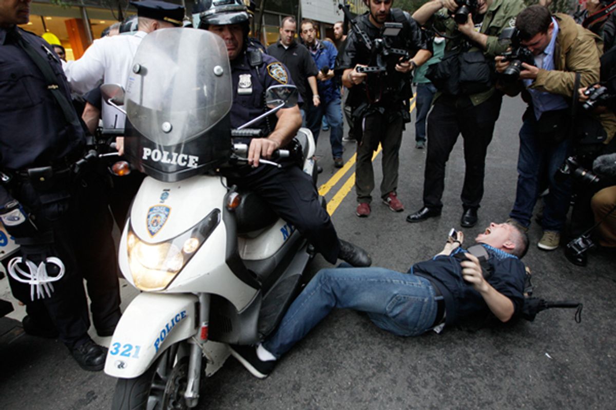 A New York City police officer runs over a National Lawyers Guild observer as Occupy Wall Street demonstrators march through the streets near Wall Street, Friday, Oct. 14, 2011, in New York.      (AP/Mary Altaffer)