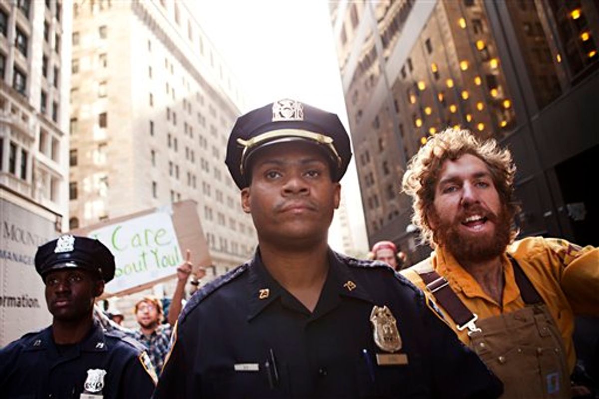 Two New York City police officers walk alongside a protestor affiliated with the "Occupy Wall Street" protests outside Zuccotti Park after the arrest of two men in New York, on Monday, Oct. 10, 2011. (AP/Andrew Burton)