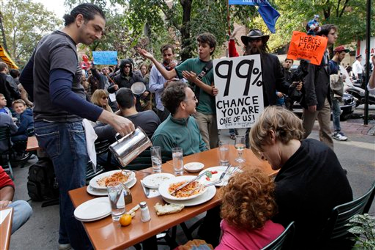 Demonstrators affiliated with the Occupy Wall Street march past a family dining at an outdoor restaurant, Saturday, Oct. 15, 2011 in New York    (AP Photo/Mary Altaffer)