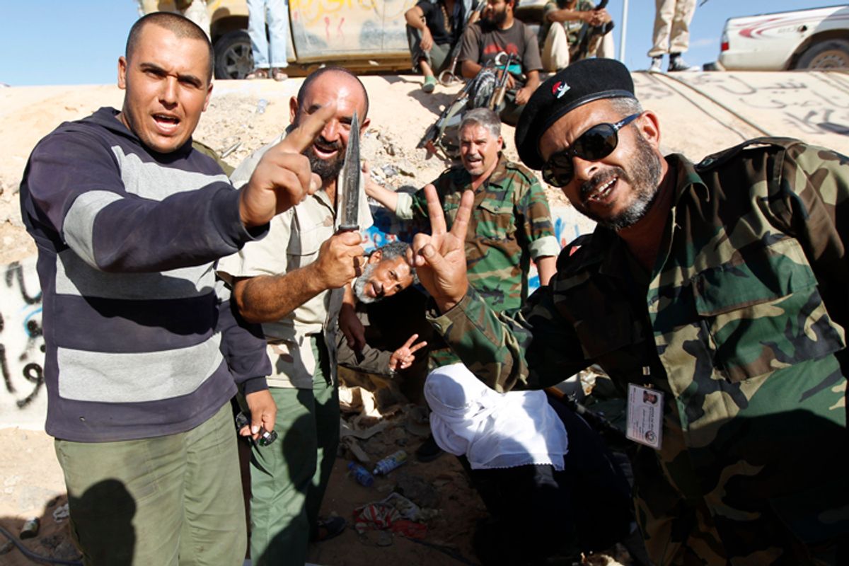 Anti-Gaddafi fighters celebrate at the drain where Muammar Gaddafi was hiding before he was captured in Sirte October 20, 2011.      (Thaier Al-sudani / Reuters)