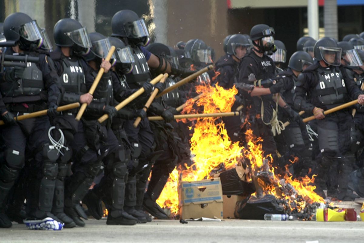 Miami riot police march through burning trash during a free trade protest in November 2003.   (AP)