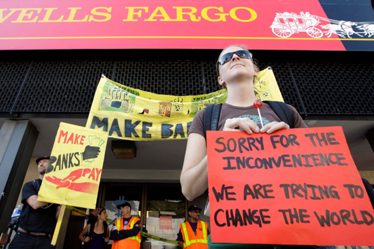 Occupy Oakland protesters stand outside of a Wells Fargo bank in Oakland, Calif., Weds., Nov. 2, 2011.      (AP/Paul Sakuma)
