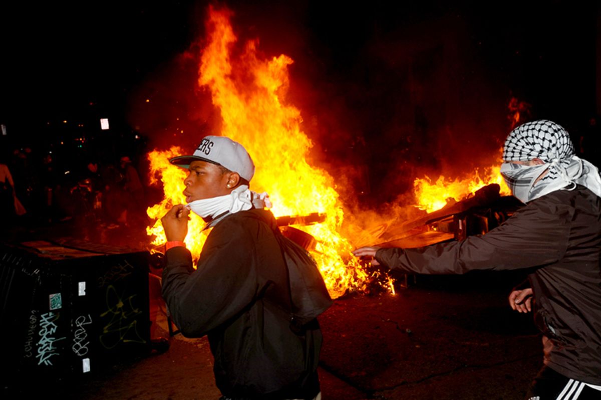 Occupy Oakland protesters pass a burning garbage heap during a confrontation with police on Thursday, Nov. 3, 2011, in Oakland, Calif.       (AP/Noah Berger)