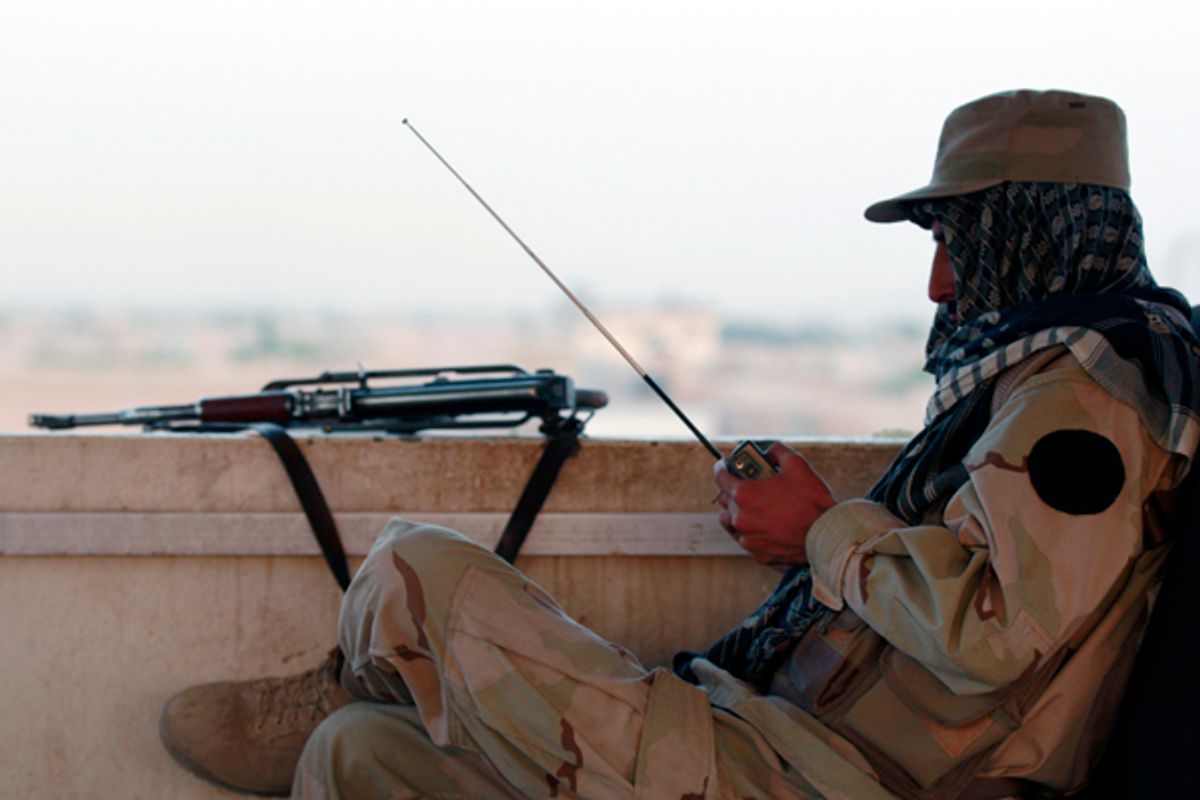 A private security organization contractor listens to a radio during his duty at guard tower in Camp Nathan Smith in Kandahar City       (Nikola Solic / Reuters)