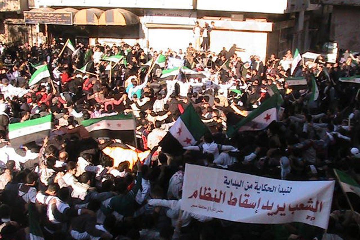 Demonstrators protesting against Syria's President Bashar al-Assad wave the old Syria flag as they march through the streets on the first day of the Muslim festival of Eid-al-Adha in Alsnmin near Daraa November 6, 2011. The banner reads, "People want the regime to step down".         (Reuters)