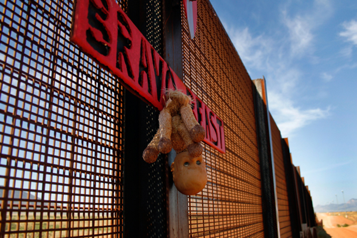  A toy doll hangs from the U.S. and Mexico border fence in Naco, Arizona September 7, 2011  (Reuters/Joshua Lott)