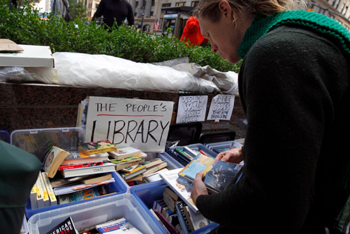 A demonstrator browses books at the library of the Occupy Wall Street protesters' camp at Zuccotti Park in lower Manhattan in New York October 3, 2011.     (Mike Segar / Reuters)