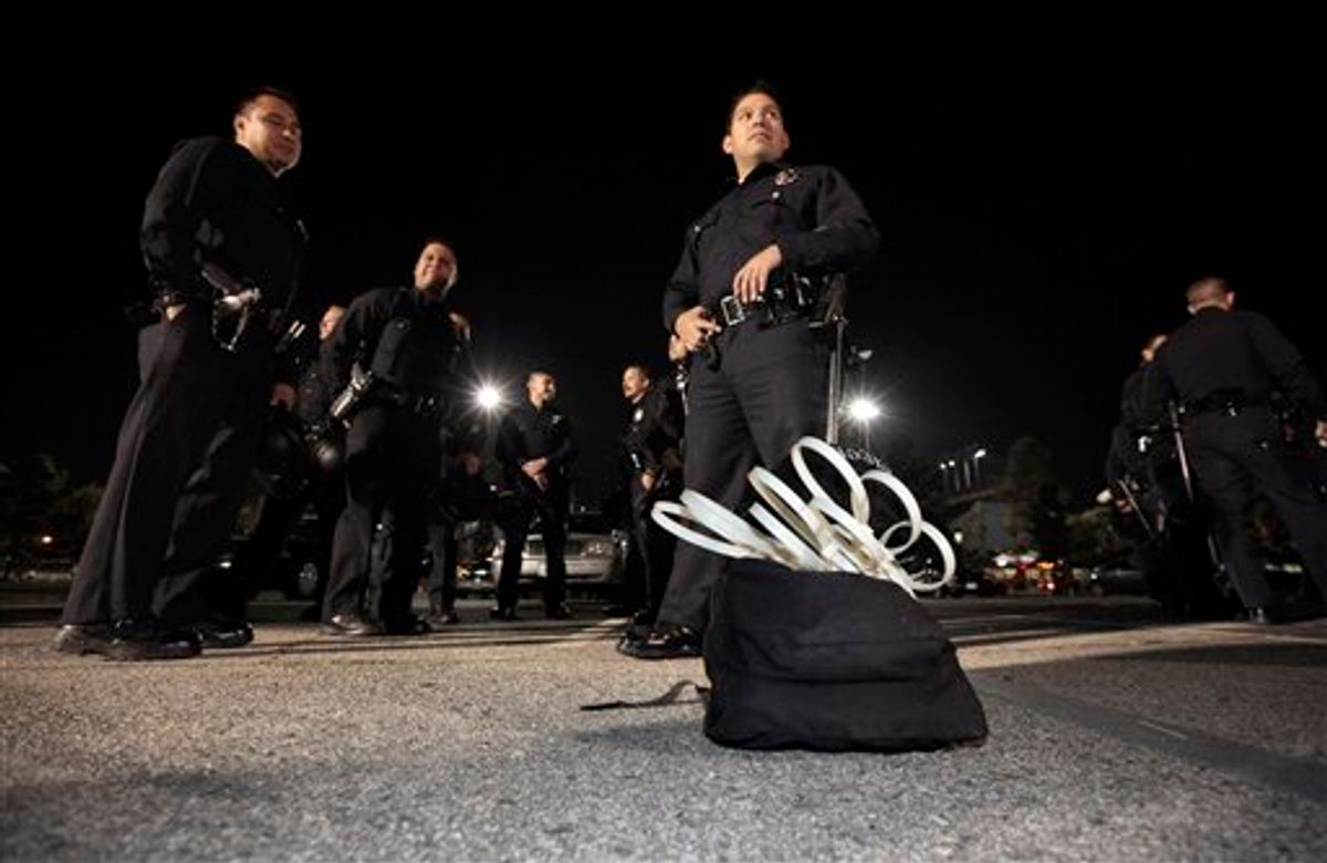 Los Angeles police officers stand by a sack containing wrist restraints late Tuesday, as they prepare to evict protesters from the Occupy Los Angeles encampment outside City Hall.   (AP/Lucy Nicholson)