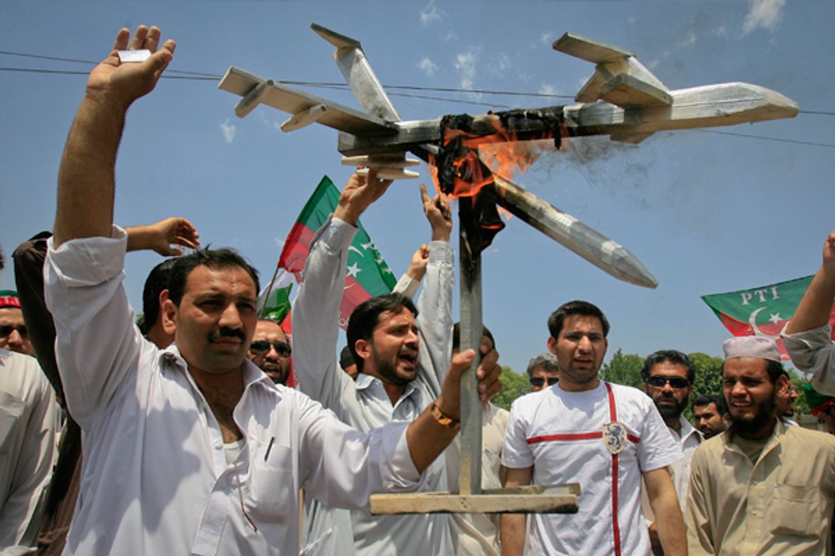 Protesters hold up a burning mock drone aircraft during a rally against drone attacks in Pakistan.         (Reuters/K. Pervez)