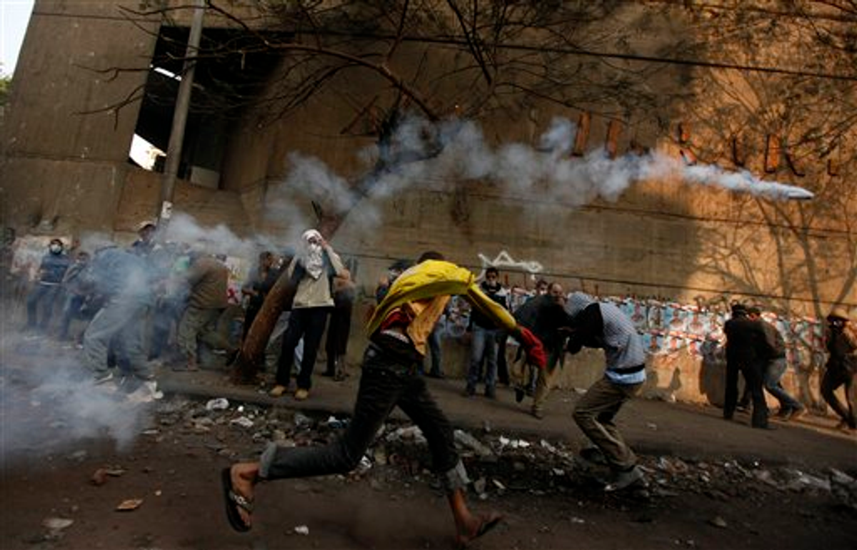 A protester throws a tear gas canister away during clashes with the Egyptian riot police near Tahrir square in Cairo, Egypt, Tuesday, Nov. 22, 2011    (AP Photo/Khalil Hamra)