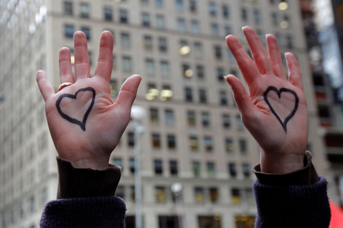 An Occupy Wall Street demonstrator raises her hands painted with hearts in New York     (Mike Segar / Reuters)