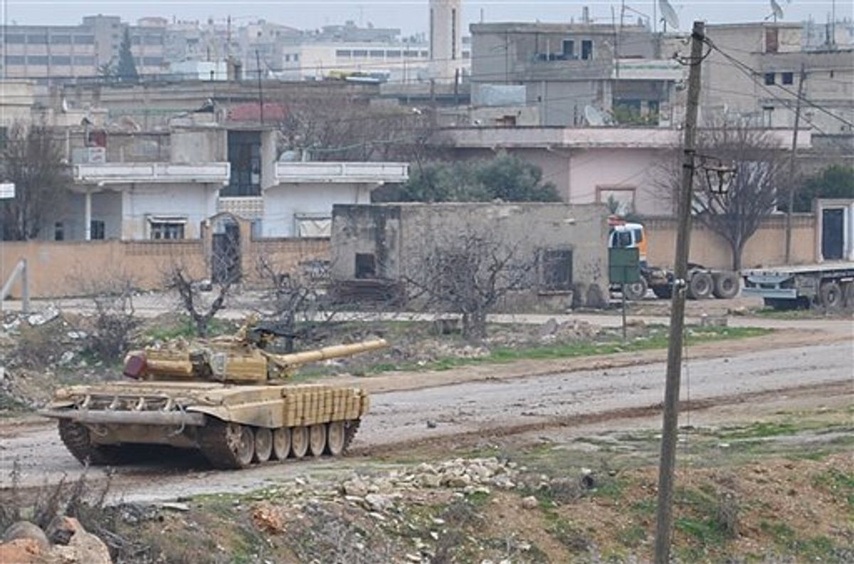 A Syrian forces tank moves along a road during clashes with the Syrian army defectors, in the Rastan area in Homs province, central Syria, on Monday Jan. 30, 2012.      (AP)