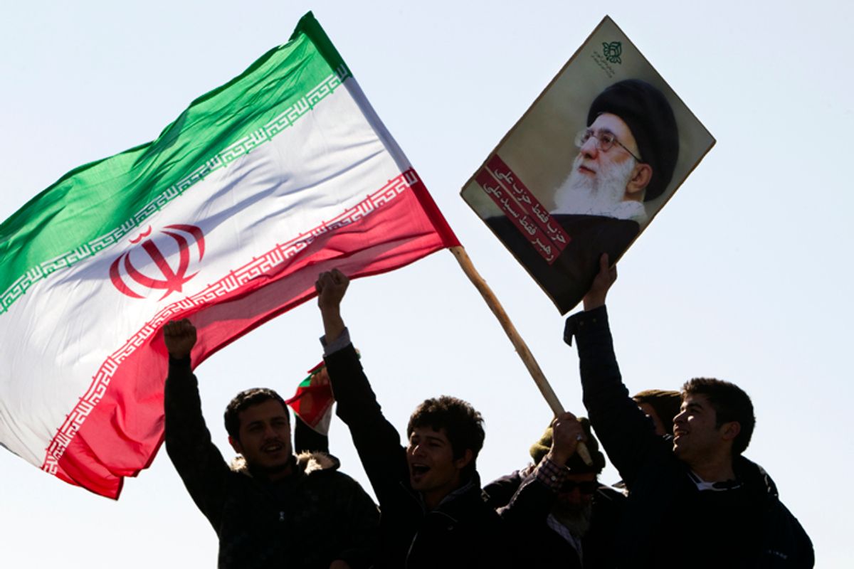 Demonstrators wave Iran's flag and hold up a picture of supreme leader Ayatollah Ali Khamenei during a ceremony to mark the 33rd anniversary of the Islamic Revolution, in Tehran's Azadi square February 11, 2012.       (Raheb Homavandi / Reuters)