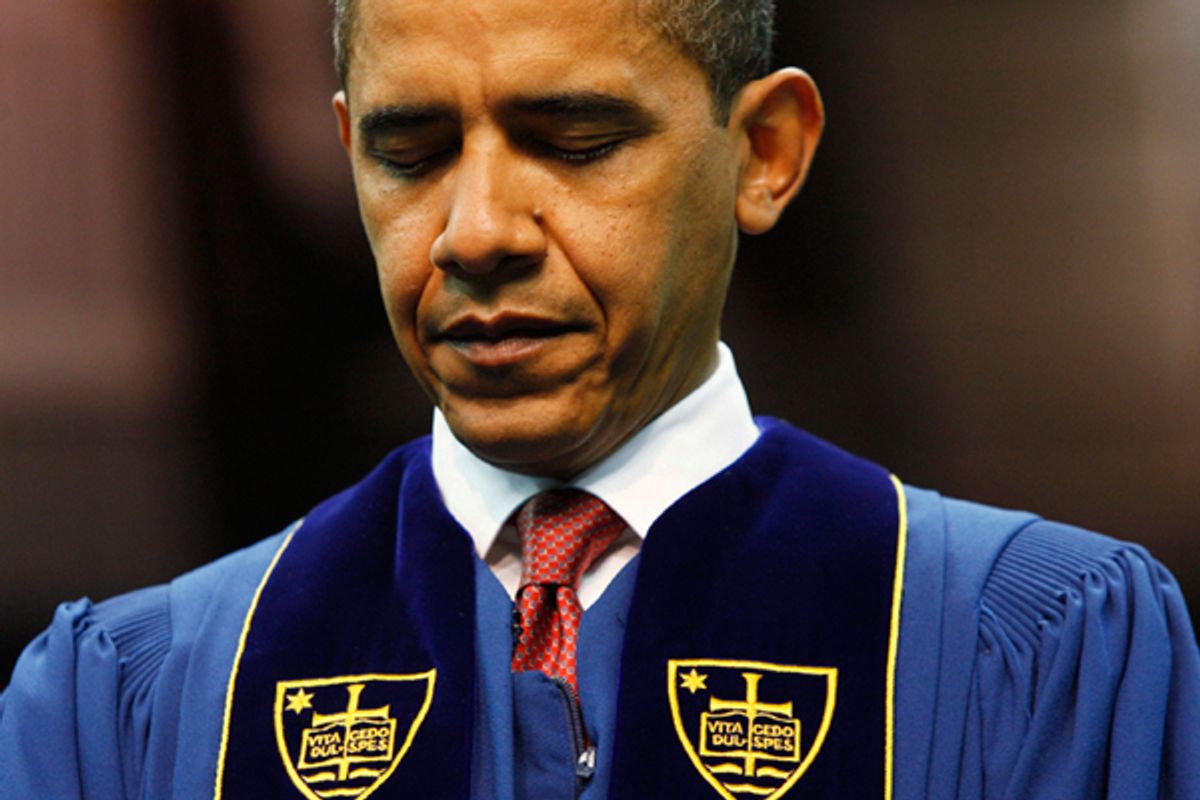 President Obama bows his head in prayer prior to speaking at the University of Notre Dame during commencement ceremonies in 2009.        (AP)