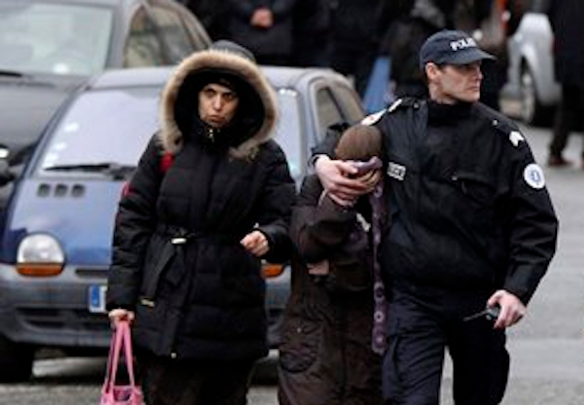 A student is flanked by an unidentified woman and a police officer as they leave a Jewish school after a gunman opened fire in Toulouse, southwestern France, Monday, March 19, 2012       (AP Photo/Manu Blondeau)