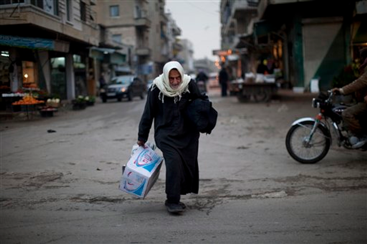 A woman walks in a street market downtown of Idlib, north Syria, Wednesday, March 7, 2012.     (AP Photo/Rodrigo Abd)