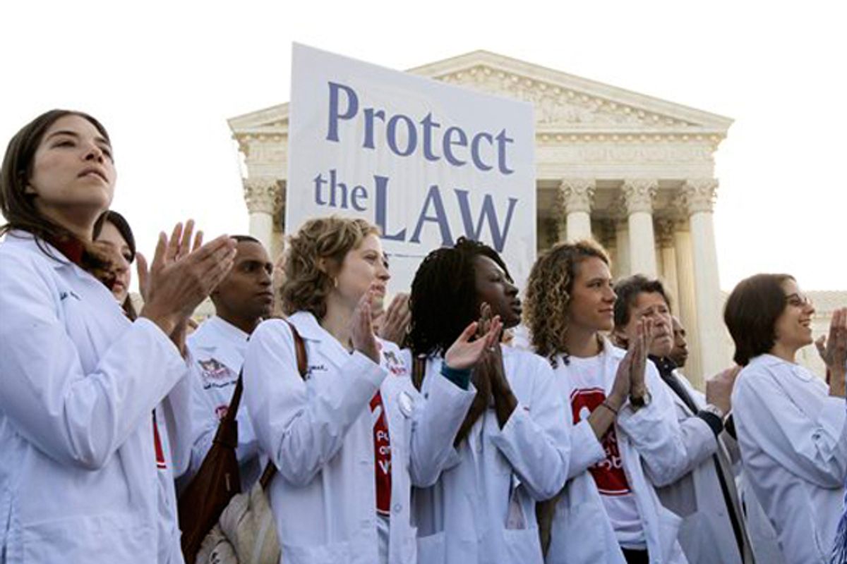 Doctors and medical students supporting President Obama's health care reform law gather in front of the Supreme Court on Monday.              (AP/Charles Dharapak)