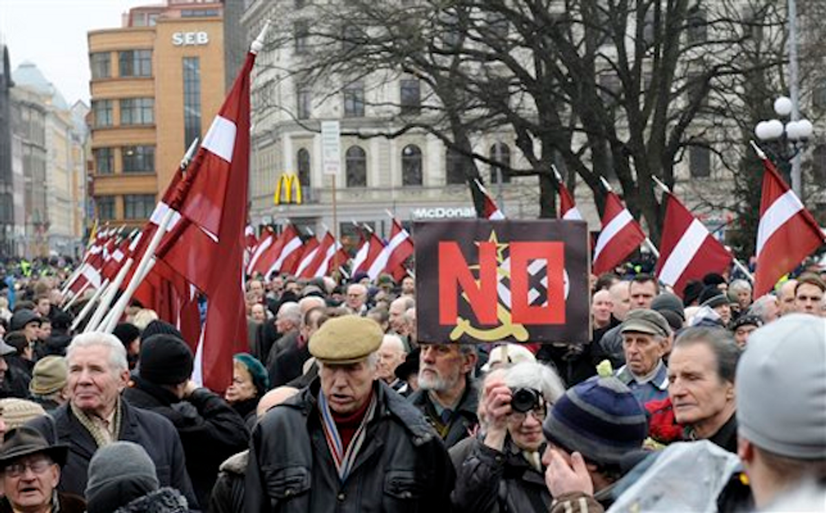 With Latvian flags, people march in a procession to honor soldiers who fought in a Waffen SS unit during World War II, in Riga, Latvia, Tuesday, March 16, 2012   (AP Photo/Roman Koksarov)