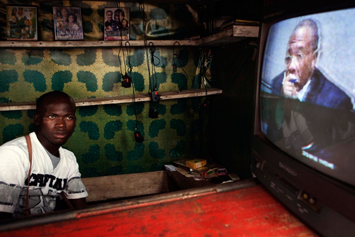 A Freetown street vendor watches a live broadcast of the  Taylor verdict being delivered.    (Reuters/Finbarr O'Reilly)