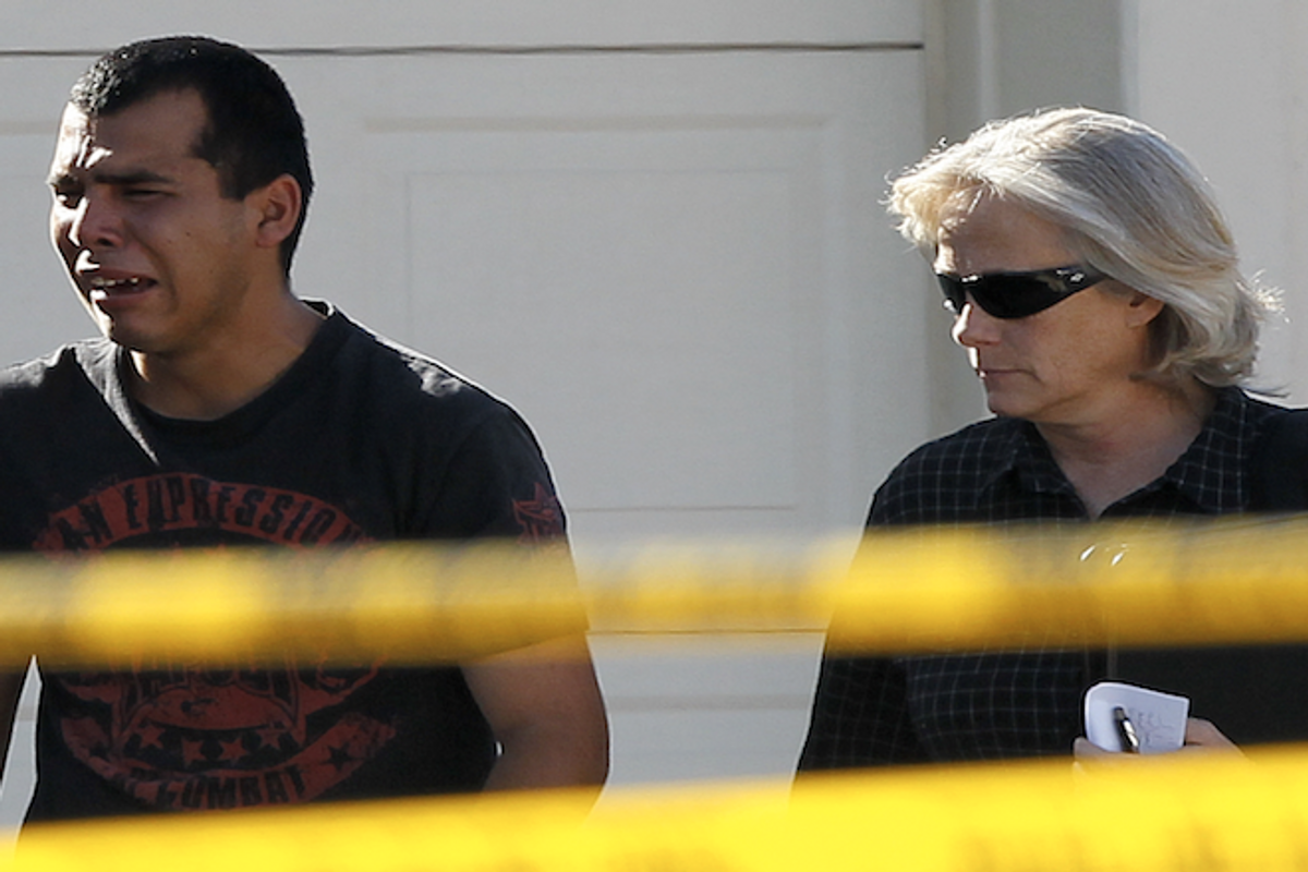 A police officer walks with a man who said he had a child inside of the home where five people were shot Wednesday, May 2, 2012 in Gilbert, Ariz.    (AP Photo/Matt York)