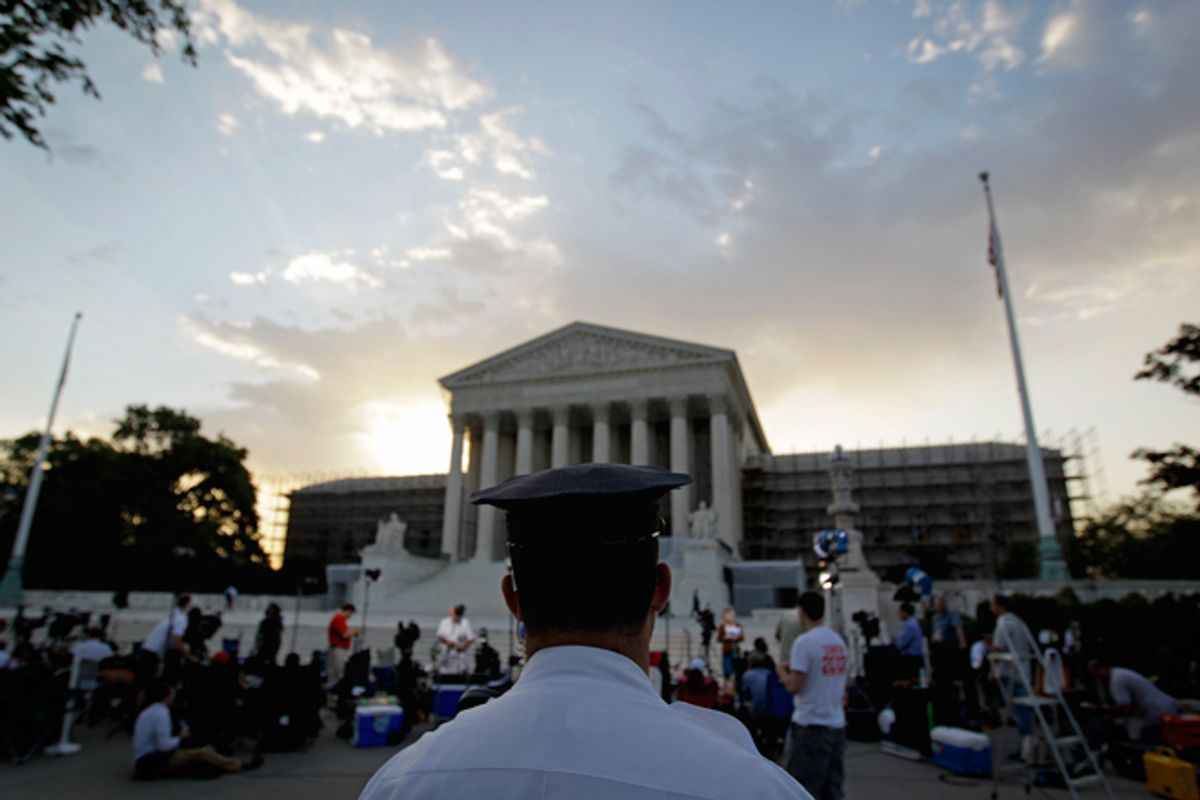 An officer stands outside the Supreme Court as media and the public gather on Thursday.   (AP/David Goldman)