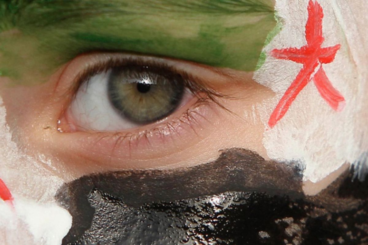 A boy with his face painted in the colours of the Syrian opposition flag takes part in a demonstration against Syria's President Bashar al-Assad.         (Reuters/Ali Jarekji)