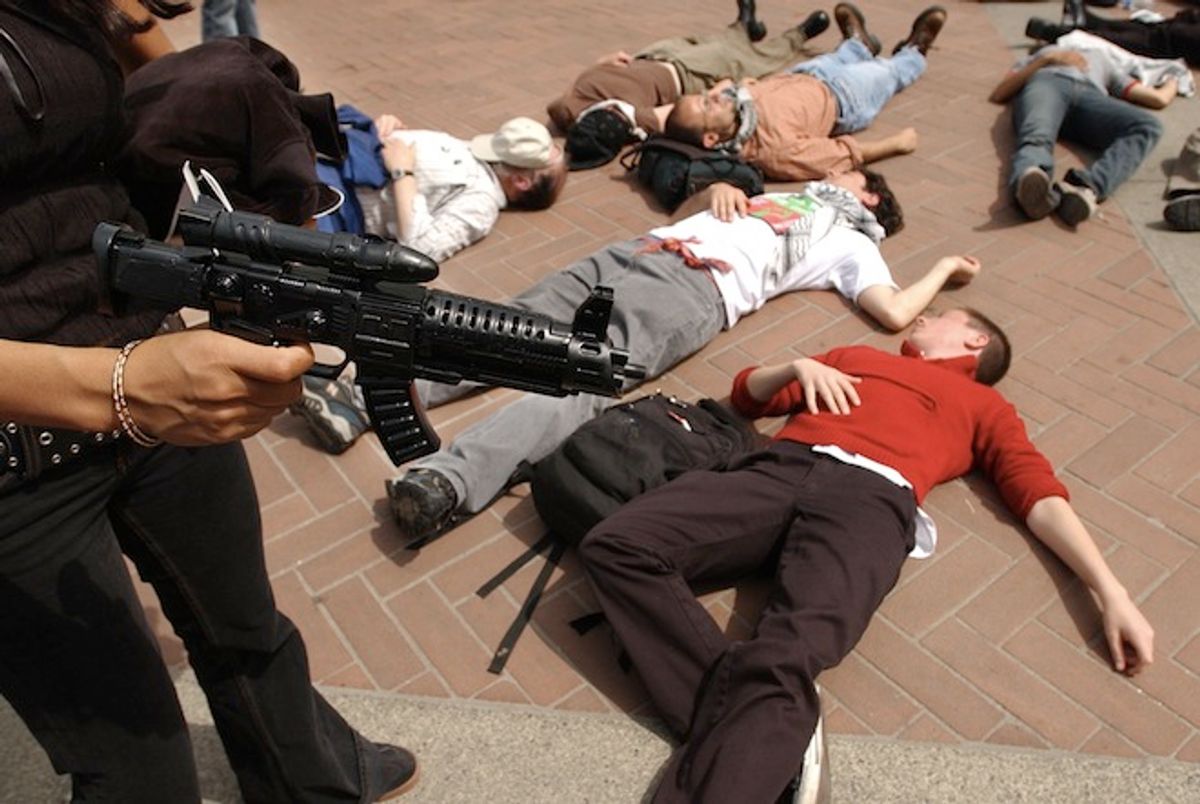 A protester holding a plastic gun stands over other demonstators with the group "Students for Justice in Palestine," during a mock "die-in"  at the steps of Sproul Plaza, Wednesday, April 9, 2003, on the University of California at Berkeley campus in Berkeley, Calif.  (AP Photo/Ben Margot)