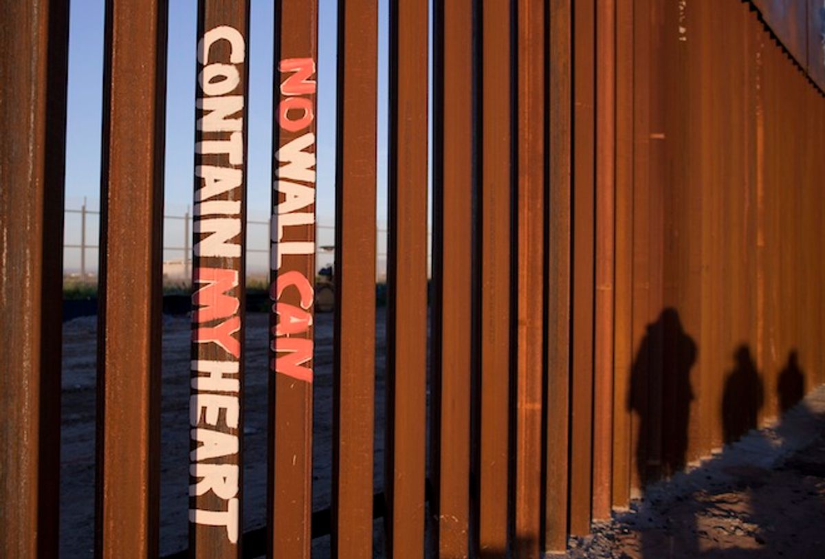 This Saturday, Jan. 28, 2012 photo shows graffiti reading "NO WALL CAN CONTAIN MY HEART" on the U.S. border fence in Tijuana, Mexico.       (AP/Julie Jacobson)