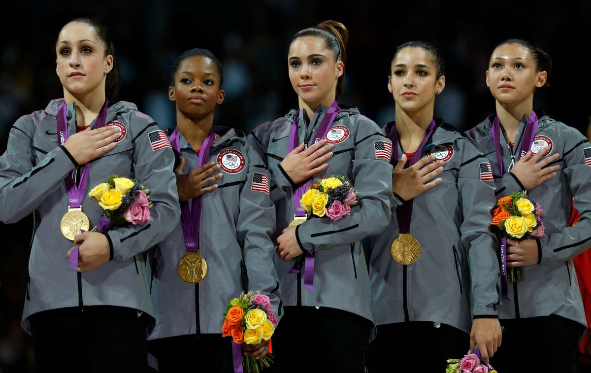 The gold-medal winning American gymnastics team listens to the U.S. national anthem (AP/Matt Dunham)