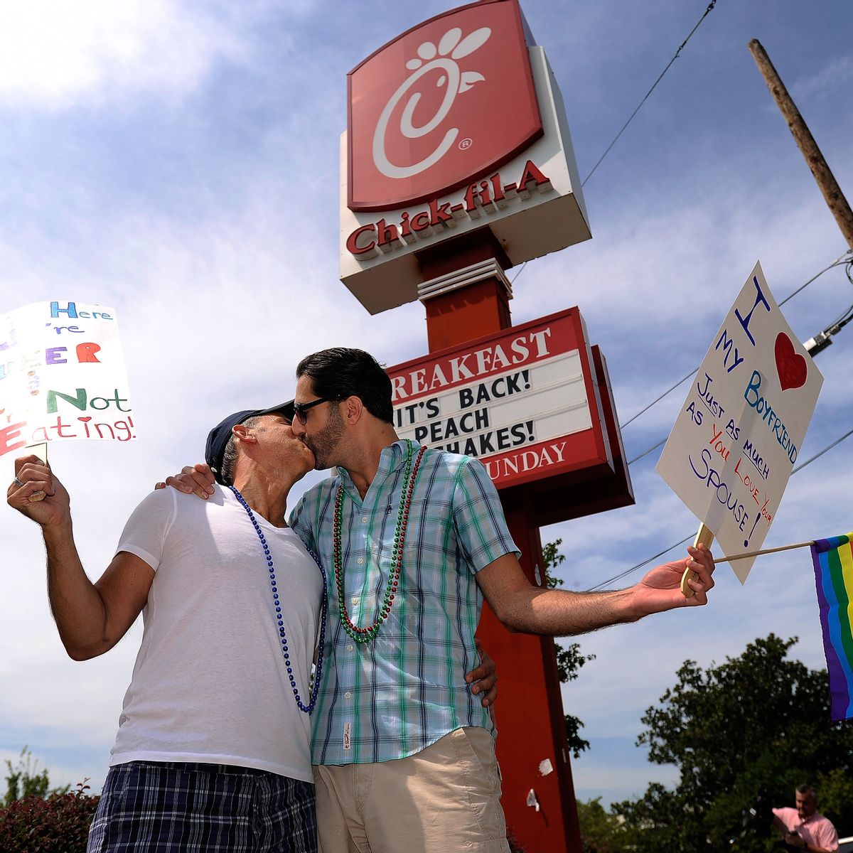Jim Fortier, left, and Mark Toomajian, kiss as they join about two dozen members of gay rights groups and others protesting outside a Chick-fil-A restaurant Friday. (AP/David Tulis)