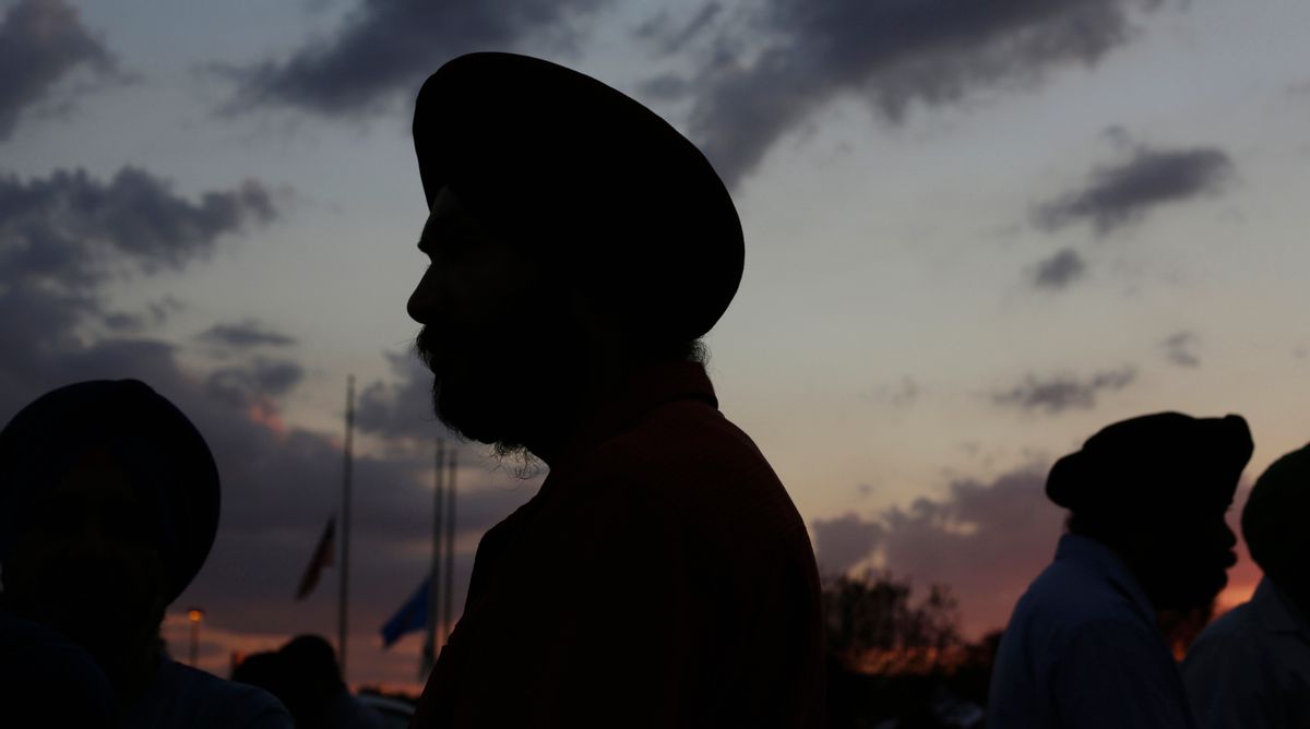 Flags fly at half-staff as Sikhs prepare for a vigil in Oak Creek, Wis., Aug. 7, 2012.     (Reuters/John Gress)