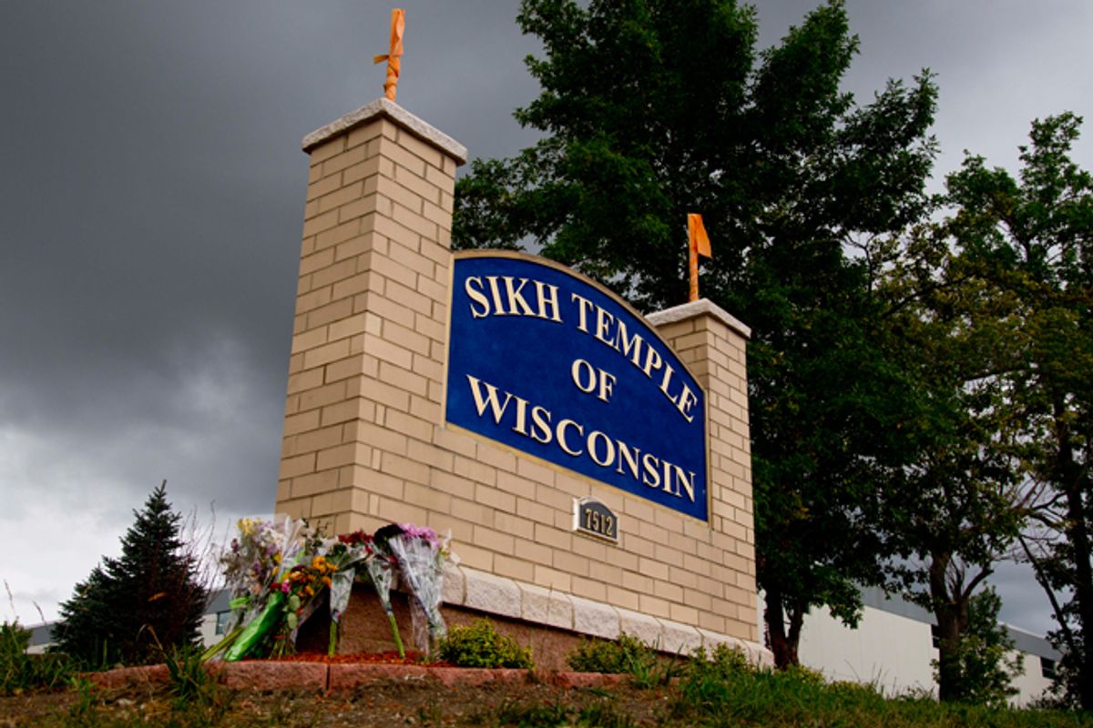 Flowers lie on the sign to the Sikh Temple of Wisconsin in Oak Creek. (AP/Jeffrey Phelps)