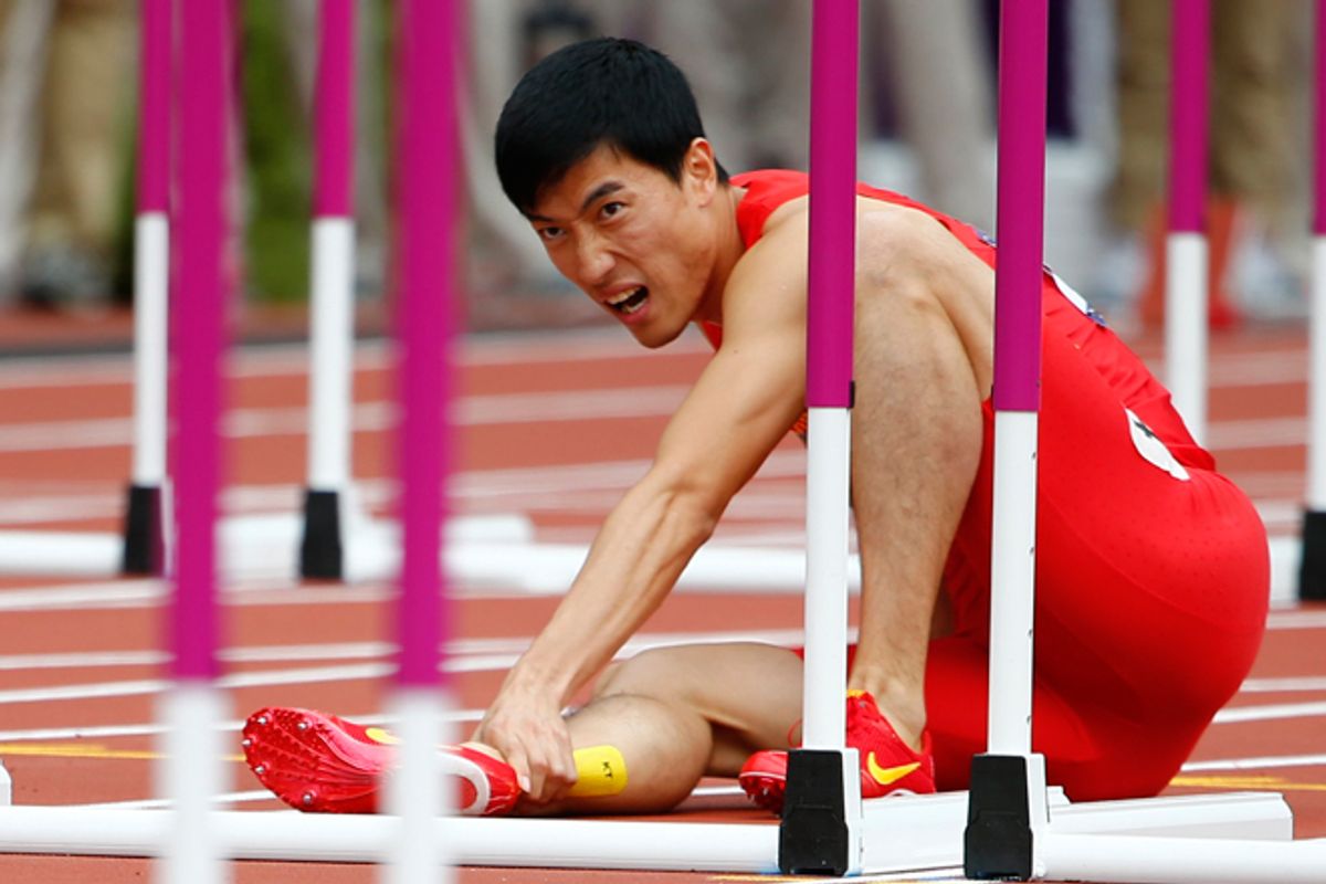 Liu Xiang holds his leg after suffering an injury at the 2012 Olympic Games on Monday.     (Reuters/Kai Pfaffenbach)