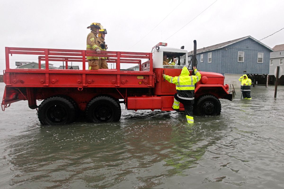 A Dare County utility worker checks with the Kitty Hawk Fire Department as they patrol flooded streets in Kitty Hawk, N.C., Monday, Oct. 29, 2012.       (AP/Gerry Broome)