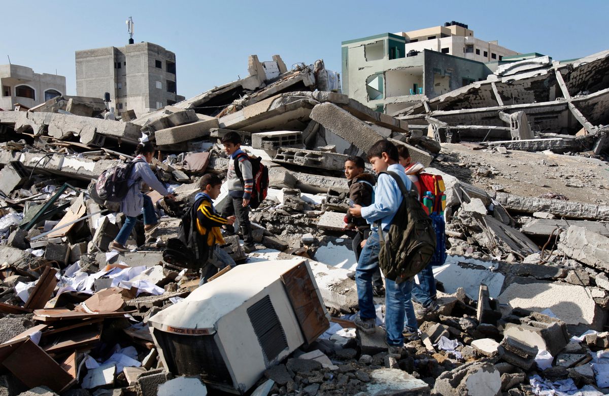Palestinian school children walk in the rubble left days after an Israeli strike destroyed the Hamas interior ministry in Gaza City.   (AP/Adel Hana)