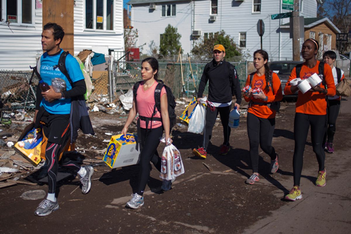 New York City Marathon runners carry relief supplies through a damaged neighborhood in Staten Island.       (Reuters/Adrees Latif)