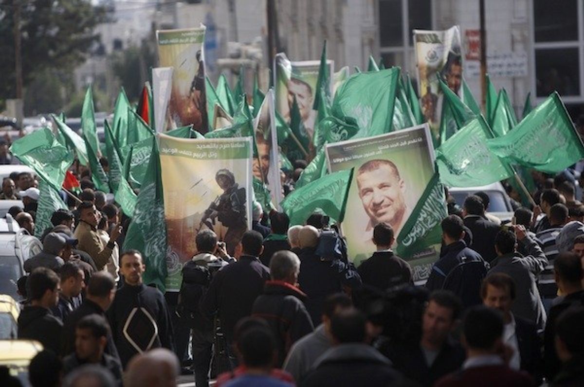 Hamas supporters in the West Bank city of Ramallah carry obituary posters of Hamas mastermind Ahmed Jabari as they march in support of the people of the Gaza Strip.  (AP/Majdi Mohammed)