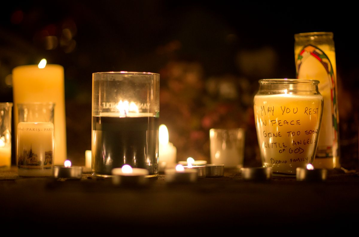 A message is seen on a candle outside the St. Rose of Lima Roman Catholic Church, Saturday, in Newtown, Conn.   (AP/David Goldman)