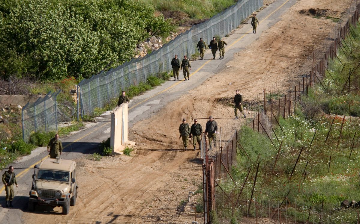 Israeli troops search for gaps in the fence along the border between Israel and Syria near the village of Majdal Shams in the Golan Heights.(AP/Ariel Schalit)     